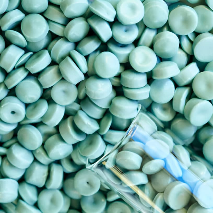 Teal-blue F7000 polyethylene granules with a test tube